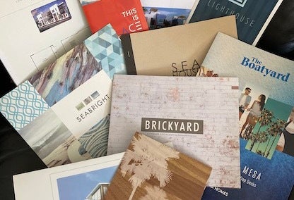 Pamphlets of new developments across Newport Beach and Costa Mesa